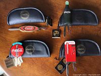 Photo showing all four Coca-Cola themed bottle openers and their matching black zippered collectible cases with gold logo.