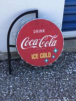 Front angle showing full Coca-Cola vintage bottle cap signage with light bulbs around edge, one bulb missing.