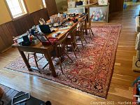 Full view of wool rug under dining table showing red and black geometric pattern