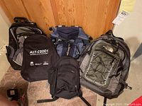 Full lot of five daypacks arranged together showing the variety in style and color.
