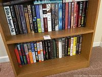 Two wooden shelves with a total of 48 hardcover fiction books, mostly crime and mystery genres.