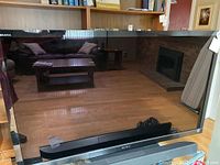 Full front view of Sony flatscreen TV showing reflective screen and soundbar in front, soundbar not included.