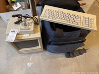 Overview of all items included in the lot: Macintosh SE computer, keyboard, joystick, and carry case.