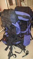 Two REI Traverse Newstar backpacks showing front and side views with straps and buckles.