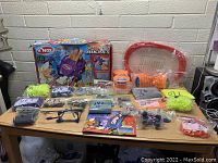 Overview of K'nex building toy set on wooden table with box, parts, and accessories