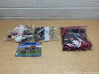 Photo showing multiple sealed bags containing LEGO City Firetruck set pieces and instruction manual on a table