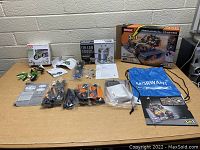 Lot of 3 kids robotic toy kits displayed on table showing all parts, manuals and boxes.