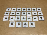 31 assorted Wheat pennies from 1918 to 1957 in protective cardboard holders with clear windows and labeled years.