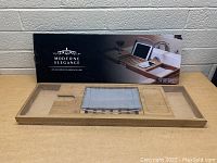 Modern Elegance bamboo bath caddy displayed with its box, highlighting its compartments, tablet holder, and adjustable width design.