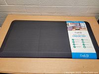 ComfiLife anti-fatigue comfort mat laying flat on a table with the packaging label visible showing features and branding.