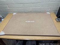 Large rectangular tan puzzle board tray with La Vie Vert logo, padded surface and corner protectors on a table.