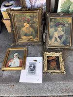 View of five art pieces grouped: two large framed prints of women by Huldah Cherry Jeffe, one smaller framed Pope John Paul II photo print, one smaller framed print of a woman, and one unframed stipple engraving print of Charles I, with protective wrapping visible