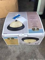 Photo of the box showing the Hampton Bay flush mount ceiling light fixture with a frosted glass dome and a dark trim ring.