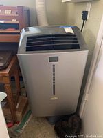 Front view showing silver housing, air intake grille and digital control panel