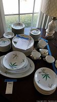 Photo showing the full set of Noritake Canton China including plates, bowls, and teacups on a table with a lamp nearby.