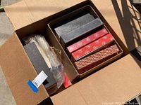 Open box showing multiple piano music roll boxes inside with patterned covers.