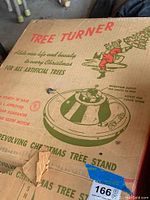 Photo of original cardboard packaging box for the revolving tree stand with vintage graphics and text.