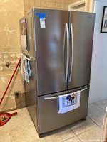 Front view of stainless steel French door refrigerator with bottom freezer drawer.