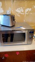 Photo of Black & Decker stainless steel 2-slice toaster on top of Panasonic microwave.