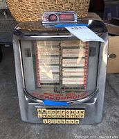 Front view showing full chrome body, curved front window with selection cards, Seeburg 160 Stereophonic logo and push-button keypad.