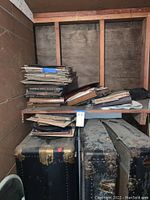 Wide view of stacked vinyl records and vintage suitcases on shelves.