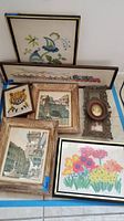 Overview of the collection showing multiple framed yarn artworks and vintage wall art including floral yarn designs, house scenes, a tiger yarn art piece, and a small carved frame with cameo.