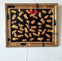 Front view of painting in its ornate gold frame hung on wall