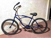 Full side view of beach cruiser bike showing frame design, wheels, saddle, and handlebars.