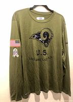 Front view of olive green LA Rams long sleeve shirt with US Military salute to service design.