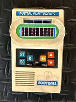 Front view of 1977 Mattel Electronics Football game showing logo, buttons, and lighted football field display.