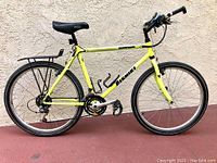 Left side view of yellow NISHIKI BackRoads bike showing frame, wheels, and rear rack.