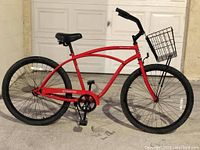 Right side view of red Phat Cycles Sea Wind cruiser bike with front basket, showing frame and tire detail.