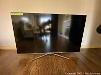 Front view of 65" Samsung TV on Y-shaped metal stand