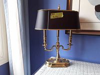 Front view of the brass candelabra-style table lamp with black horseshoe shade