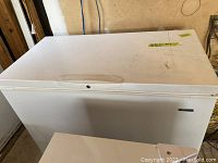 Closed white chest freezer showing size and external condition.
