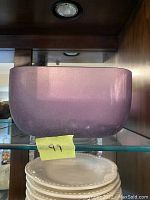 Purple frosted Murano glass bowl displayed on a glass shelf with a yellow tape label marked '99'.