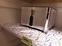 Side angled view of rectangular jewelry box showing mirrored vertical panels, black tassel, and ornate metal feet.