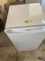 Exterior photo of a white Sunbeam bar fridge, showing the overall condition and brand logo.