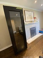 Full view of vintage black Keeper brand wine fridge standing upright with glass door.