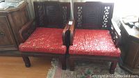 Two matching rosewood armchairs side by side showing front view