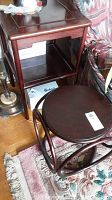 Photo showing both the taller rectangular table with shelf and the smaller round accent table placed near a couch and lamp.