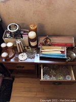Overview of all candles, holders, and boxes on wooden furniture showing variety and condition.