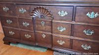 Front view of the dresser showing brass handles and carved design