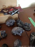 Multiple small stone bear sculptures with detailed fur texture and shaped faces.