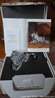Seated crystal lion in open presentation box with CoA booklet visible