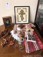 Lot overview showing handcrafted wooden pens, embroidered cloths and pillows with colorful Ukrainian folk designs, keychains, and hand-painted egg in felt lining.