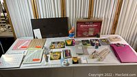 Full view of the artist collection items laid out on a table including wooden art case, Crayola crayons and markers, colored pencils, brushes, stamps, and memo board.