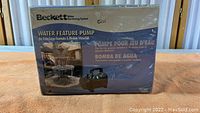 Front view of the sealed Beckett Water Feature Pump box showing product name and fountain image