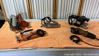 Wide photo of all five tools: Montgomery Ward circular saw, Chicago Cut Out Tool, Cut Off wheel tool, Sloan Ashland drill, and Wen belt sander on orange cloth.