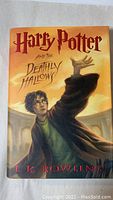 Front cover of the book dust jacket showing Harry Potter casting a spell with title and author name.